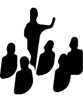 A speaker with a raised arm standing over a seated audience, in silhouette